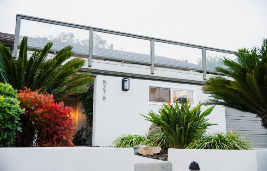 A stylish accessory dwelling unit (ADU) with a sleek, contemporary design, featuring lush landscaping and an upper-level deck with glass railings. Perfectly integrated with the main home for added functionality and aesthetic appeal.