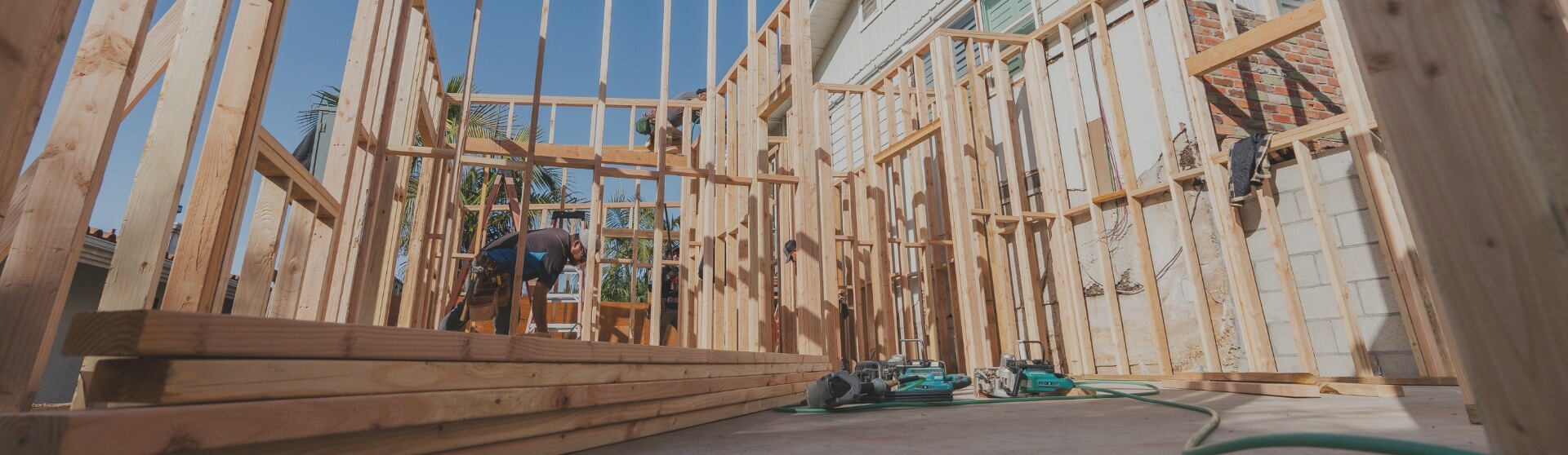 Close-up shot of ADU framing in Escondido, capturing the construction phase with wood beams and professional builders on-site.