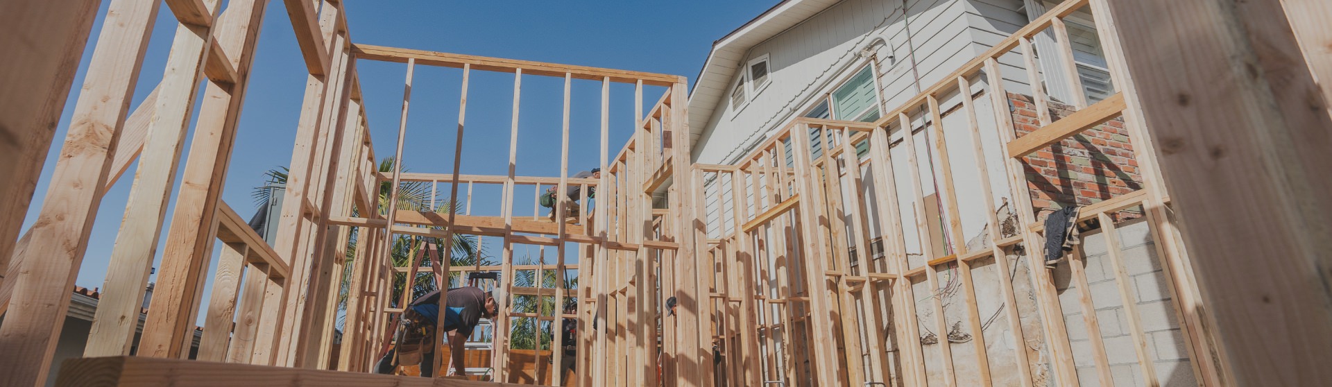 Garage Conversion Construction ADU – Skilled builders framing a high-quality garage conversion in progress under clear blue skies.