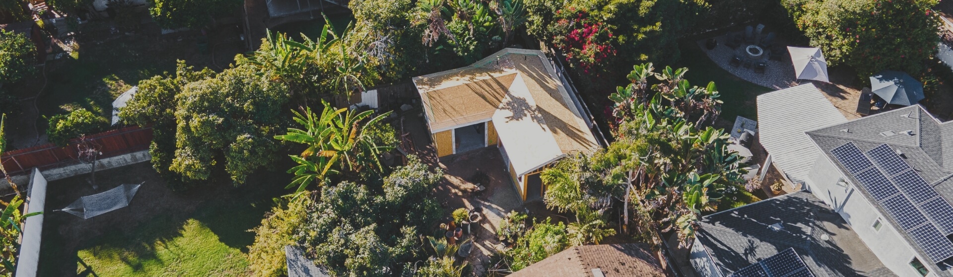 Aerial view of an ADU under construction in Rancho Santa Fe, surrounded by lush greenery and neighboring homes.