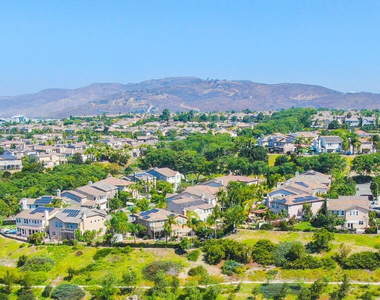 Aerial view of a residential neighborhood in Santee, ideal for ADU construction, with scenic hills in the background.