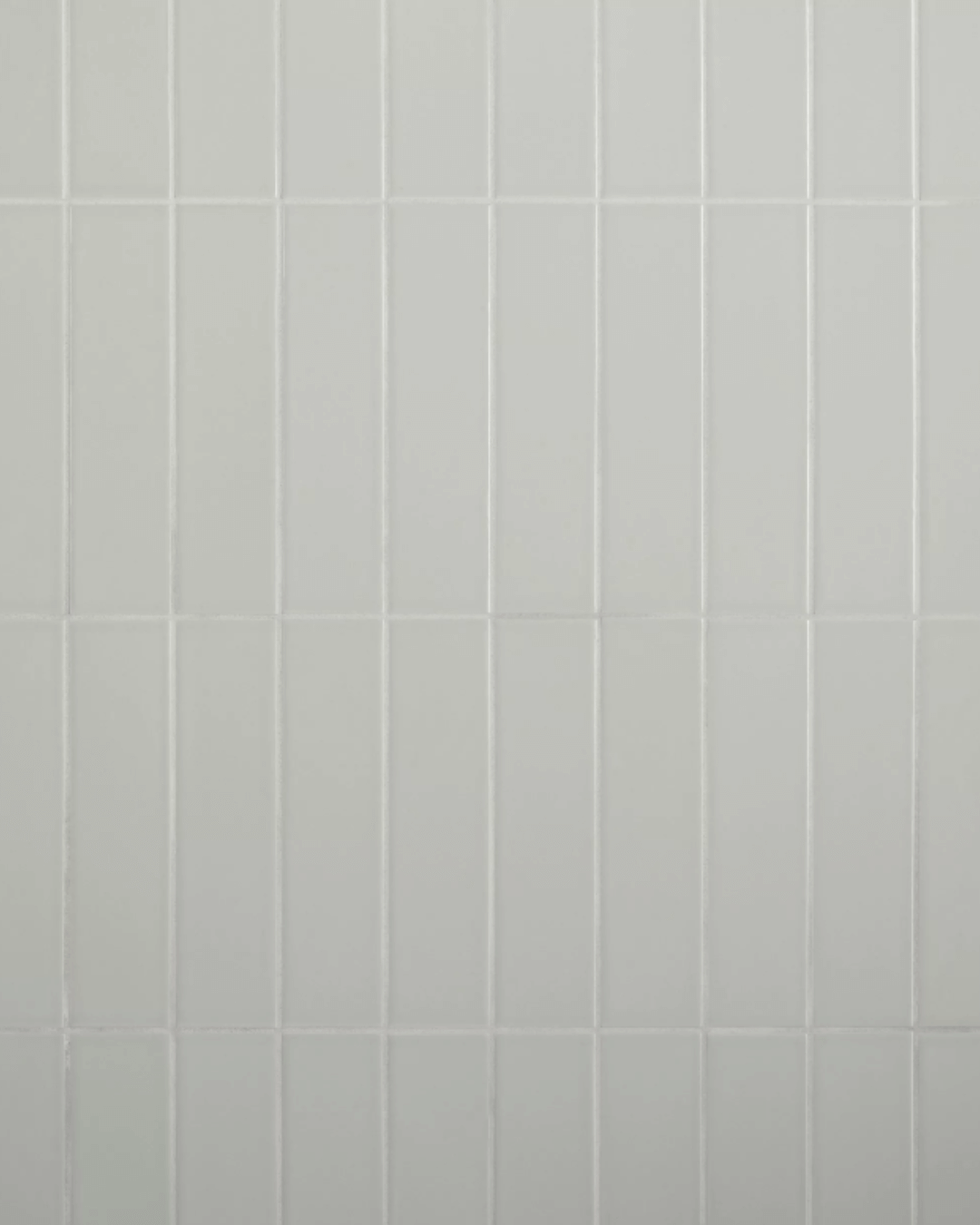 Aloe matte ceramic stacked tile in soft grey-green, featuring a clean vertical alignment, ideal for modern backsplashes and shower surrounds.