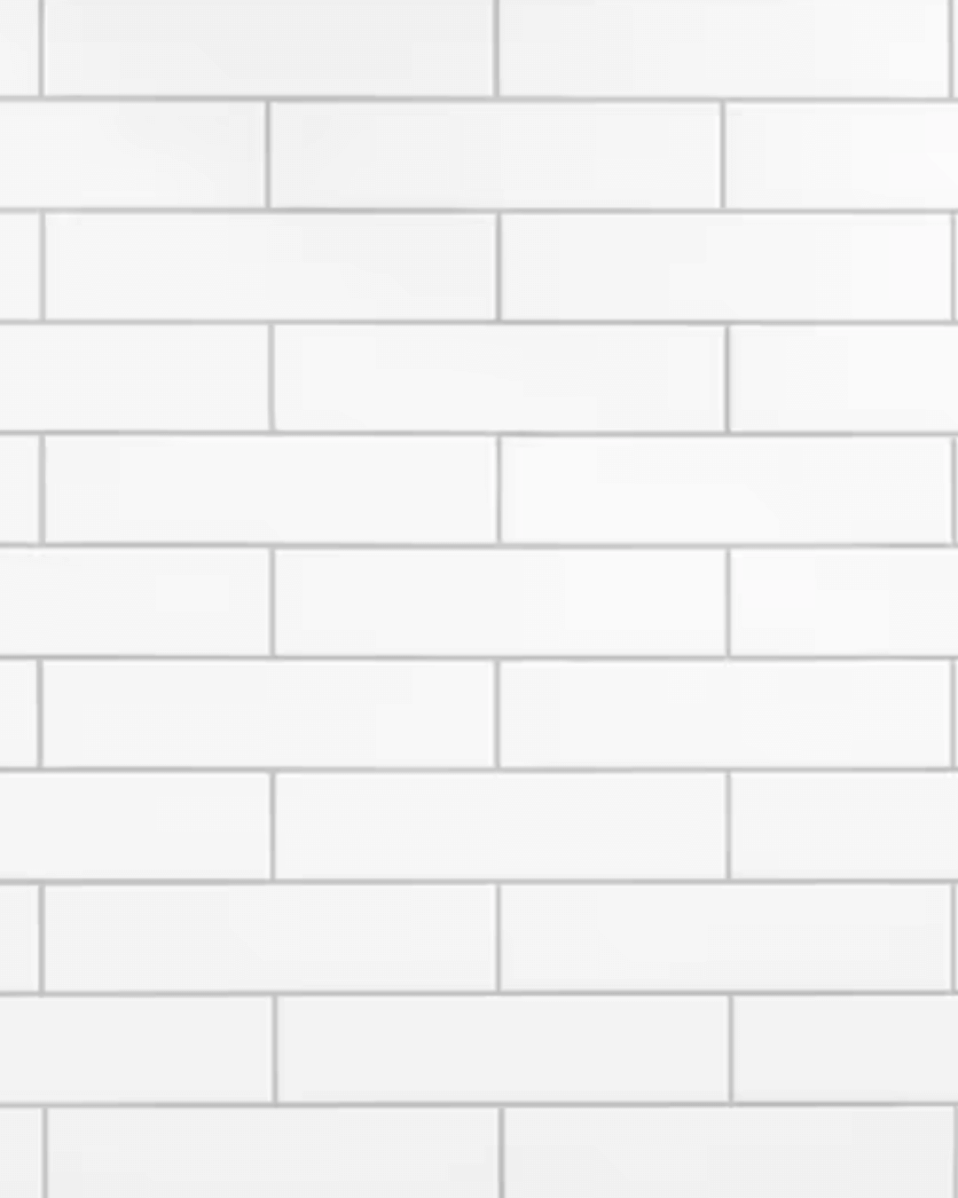 Wall covered with classic white ceramic subway tiles in a staggered horizontal pattern.