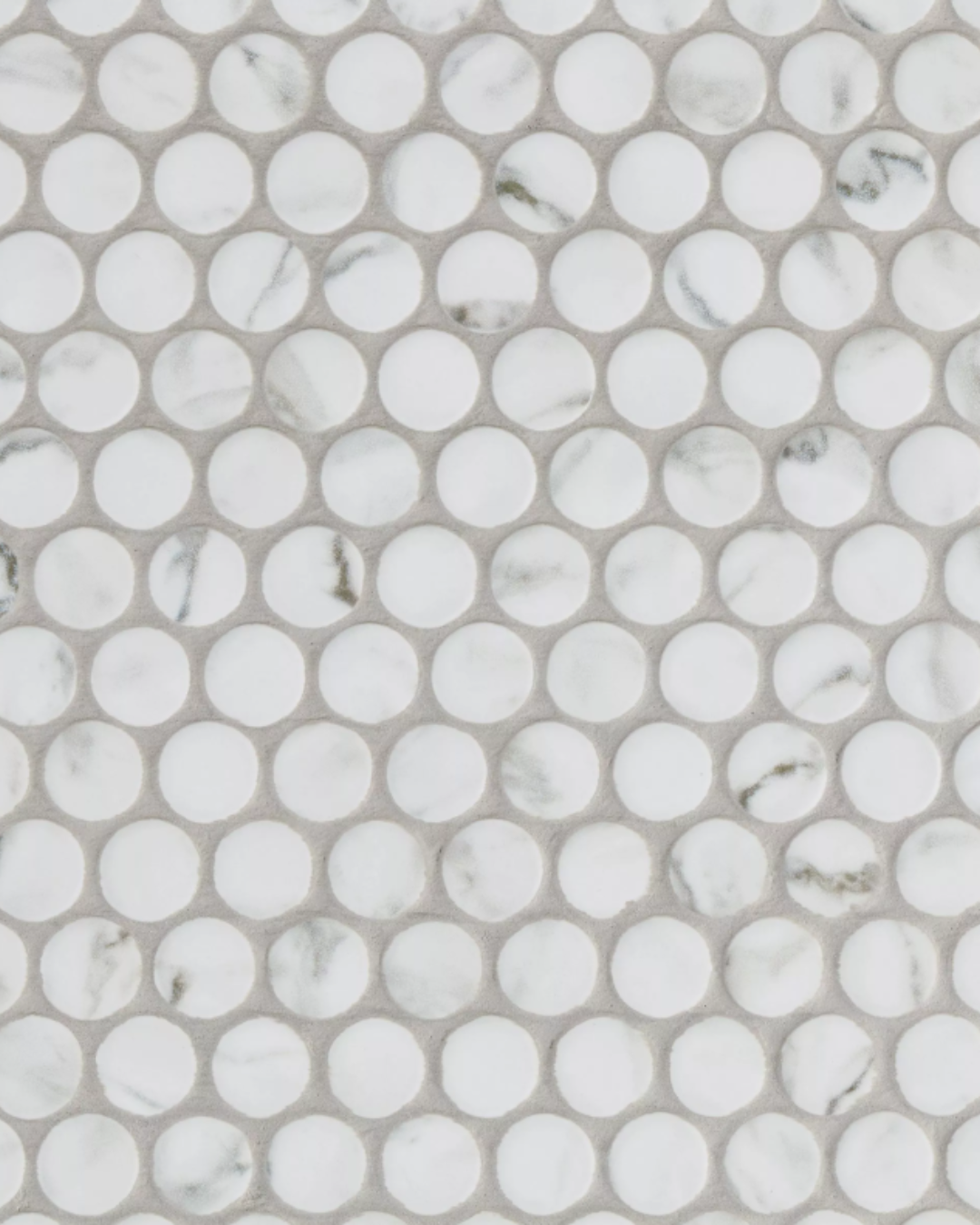 Round penny mosaic tile featuring white Carrara marble-look porcelain with subtle grey veining.