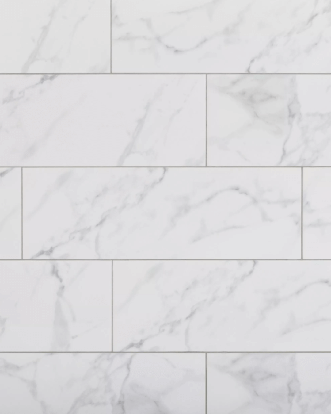 Polished ceramic wall tiles in Carrara marble pattern, arranged horizontally.