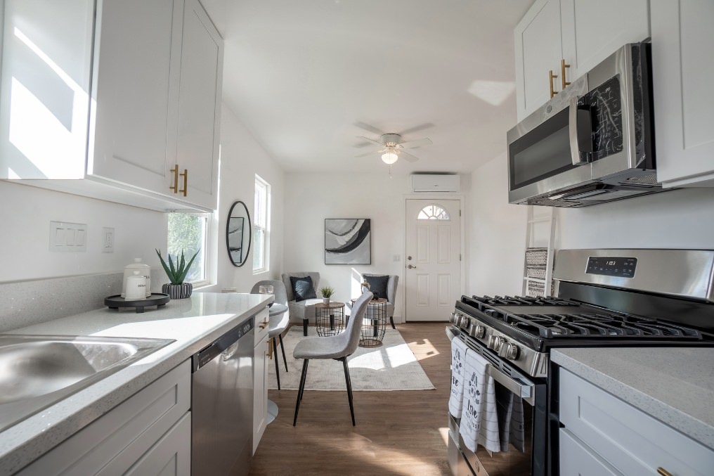 Sunlit kitchen with stainless steel appliances overlooking the cozy living space in La Mesa garage conversion ADU.