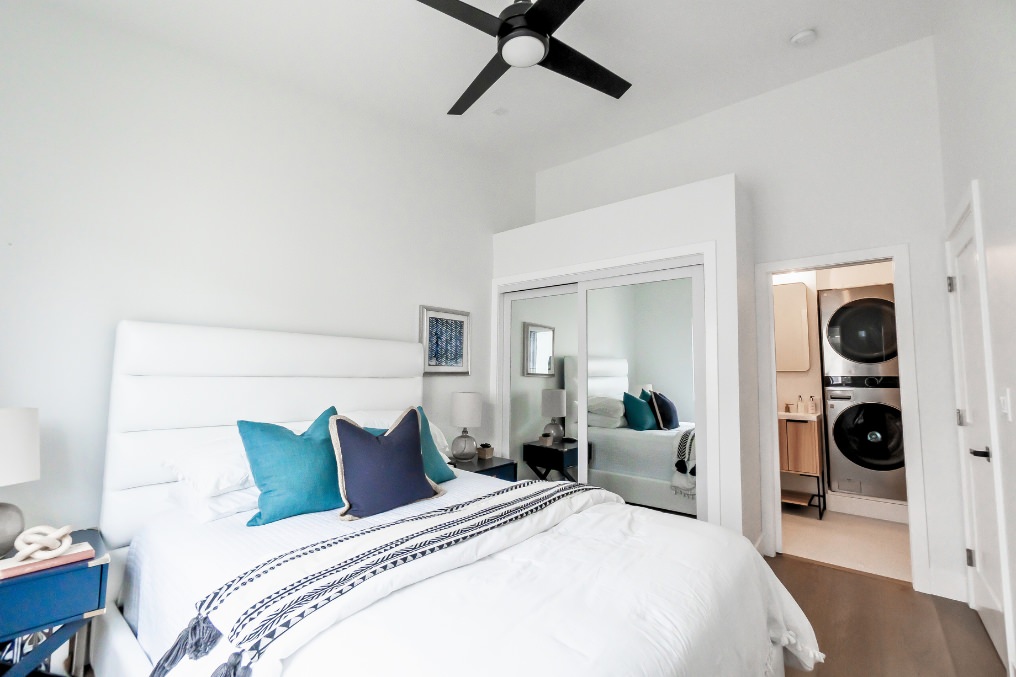 Elegant bedroom suite with built-in laundry, modern decor, and stylish bedding