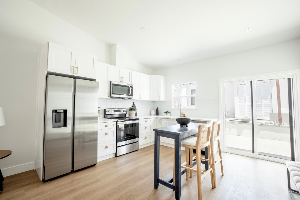 Close-up of contemporary white kitchen with stainless appliances and hexagon tile backsplash