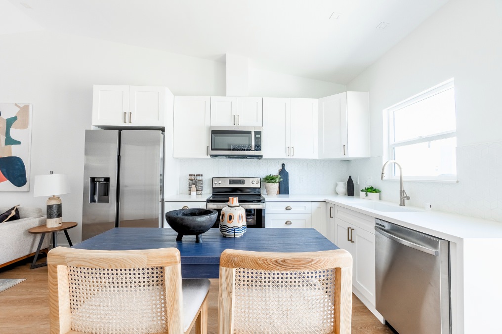 Clean, minimalist white kitchen design with stainless steel appliances in ADU