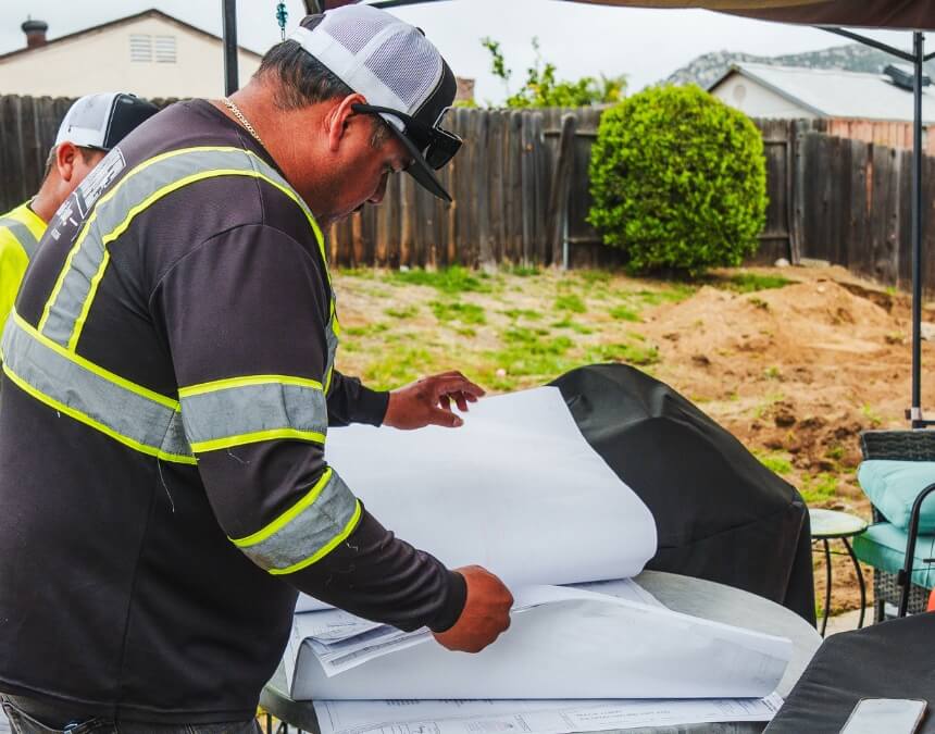 Contractor reviewing ADU permit plans outdoors – How to Breeze Through the Process.