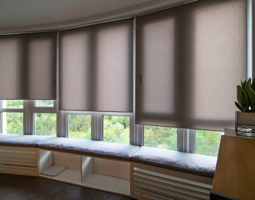 Automated blinds covering wide windows, optimizing natural light and privacy for the living space.