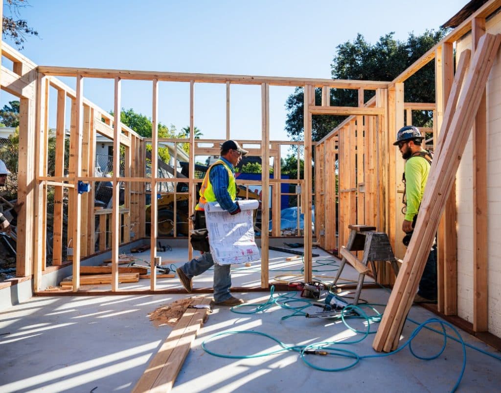 Construction team working on framing a new ADU, illustrating size-related cost factors.