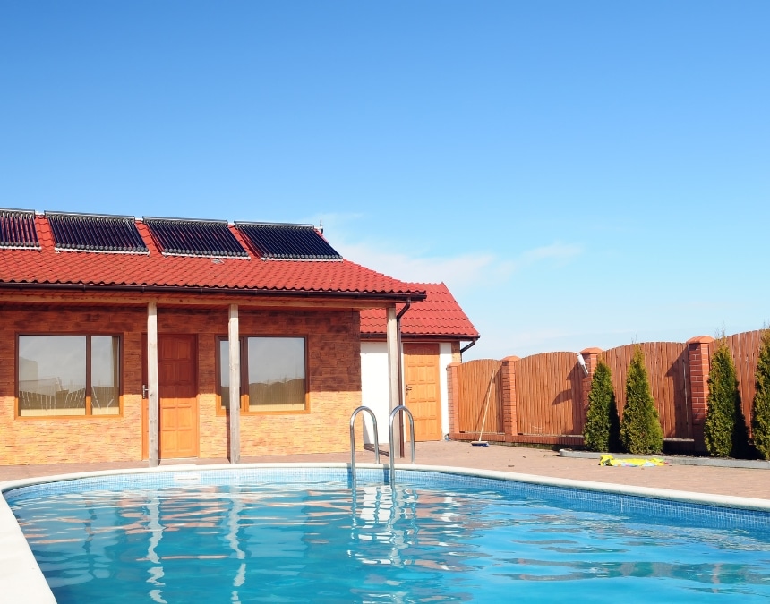 Backyard ADU with rooftop solar panels next to a swimming pool, illustrating solar panel incentives for ADUs in Greater San Diego. Highlights the benefits of incorporating solar energy in ADUs, allowing homeowners to reduce energy costs and take advantage of local and state solar incentives, promoting sustainable living solutions.