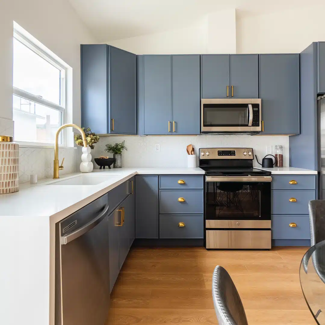 Stylish kitchen in a San Diego ADU, featuring blue cabinetry, stainless steel appliances, and a spacious countertop layout. Showcases a blend of modern design and functionality, ideal for compact living spaces while offering a high-end feel.