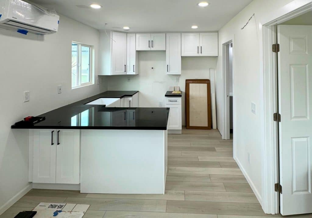 Interior of a fully equipped ADU kitchen with modern finishes, demonstrating the essential amenities needed for independent living.