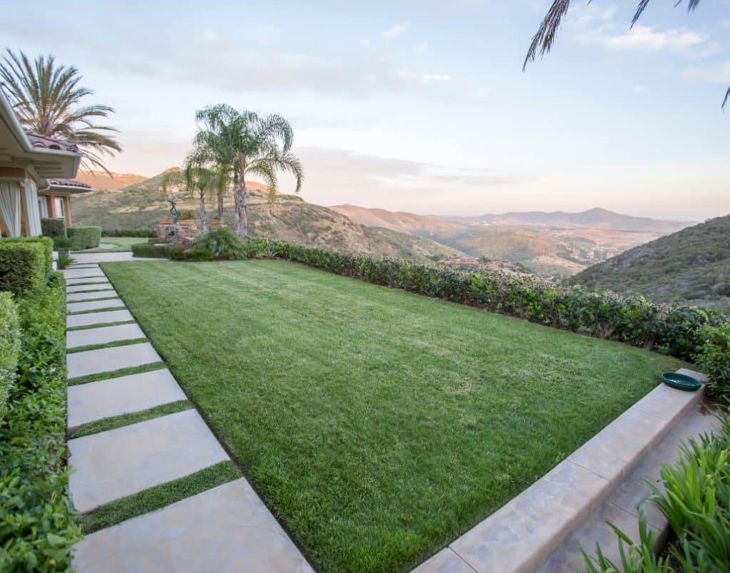 A picturesque view of a manicured lawn with a mountain backdrop showcasing the aesthetic appeal of outdoor landscaping.