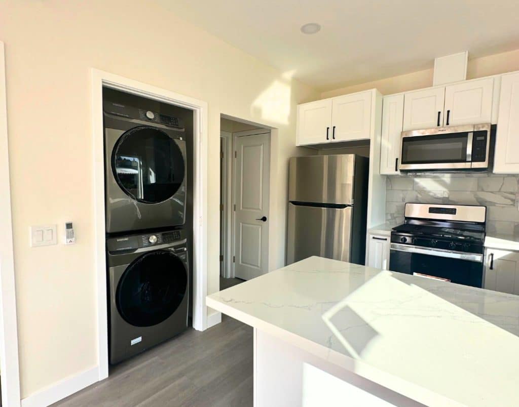 A modern ADU kitchen featuring stacked appliances and cabinets for ample storage solutions.