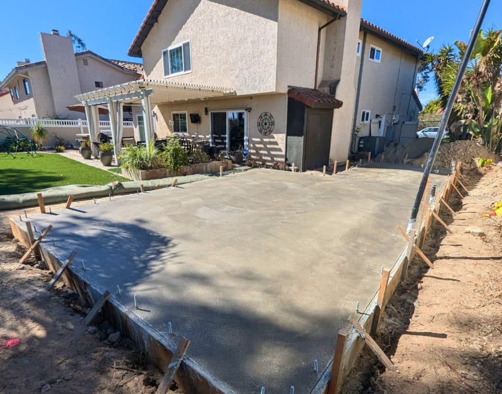 A completed concrete foundation for an ADU, surrounded by a prepared construction site.