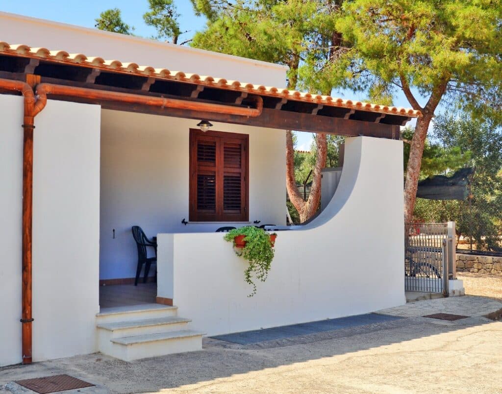 Spanish-style ADU entrance showcasing wood-framed windows and curved architectural details.