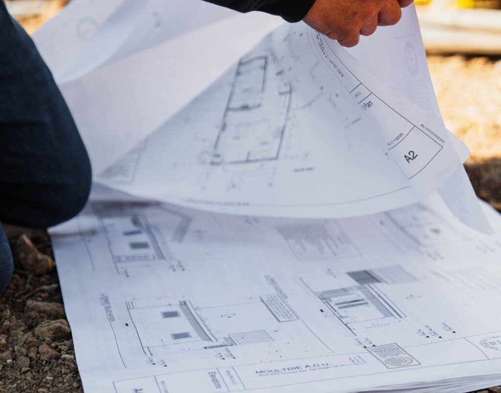 ADU blueprints laid out during site planning for permit-ready adjustments.