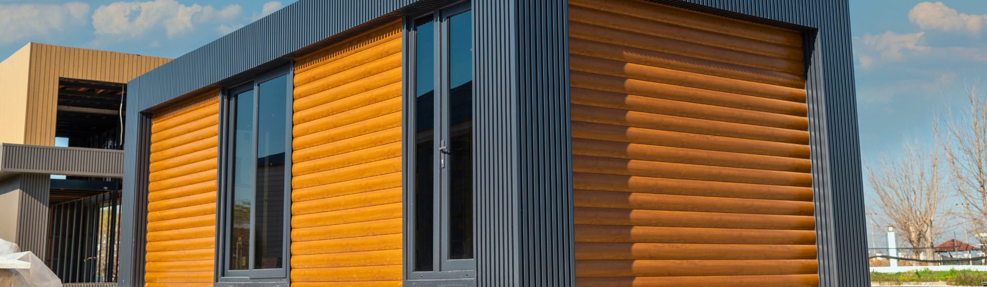 A modern prefab ADU with sleek wooden siding and black accents, showcasing the clean and stylish design possible with modular construction.