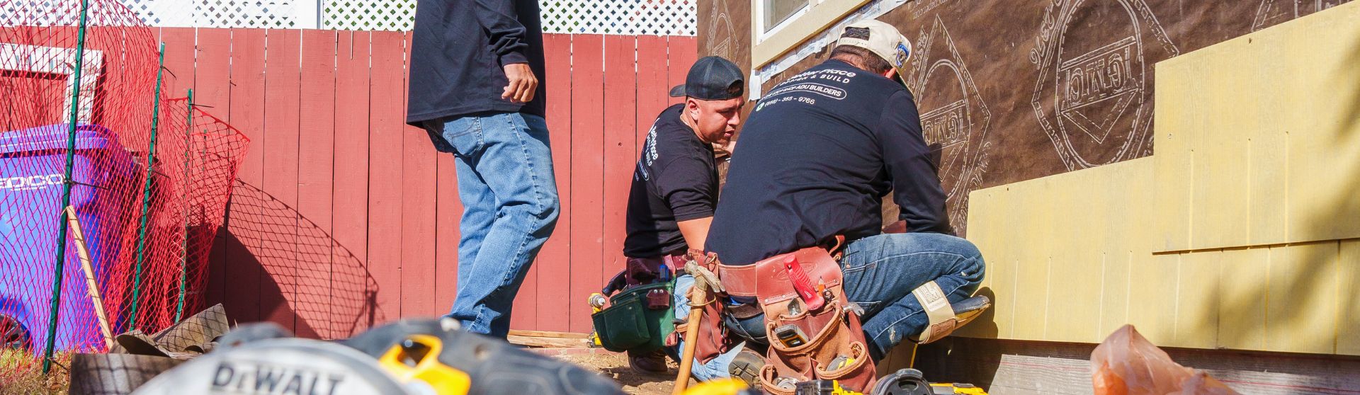 Construction workers discussing over blueprints on a building site in San Diego