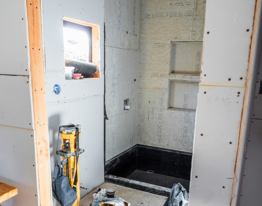 Partially finished ADU bathroom under construction, showing plumbing work in progress.