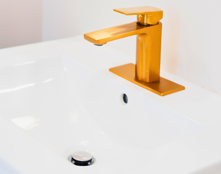 Close-up of a luxury gold faucet installed in an ADU, emphasizing hidden plumbing costs.