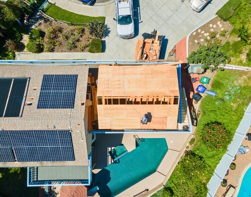 Title 24 solar panel requirements for ADUs - aerial view of a house with solar panels and an ADU under construction.