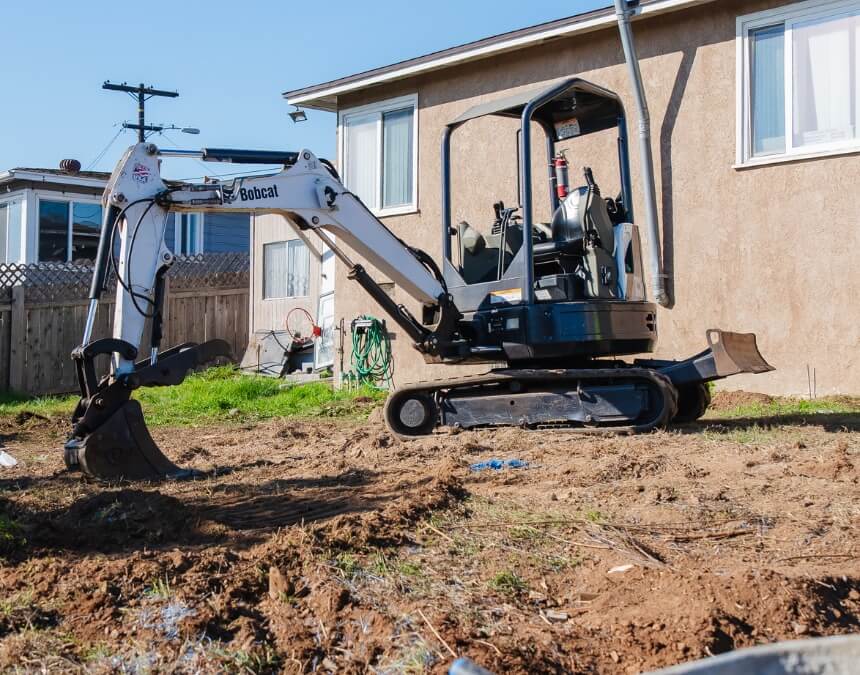 Bobcat excavator next to house can you tie into an existing septic tank for your ADU