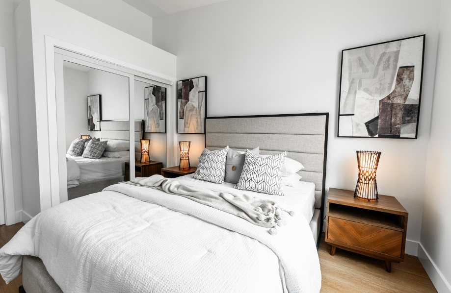 Stylish bedroom setup in Sandalwood adu 2 bedroom featuring mirrored closet doors, abstract art, and modern lighting
