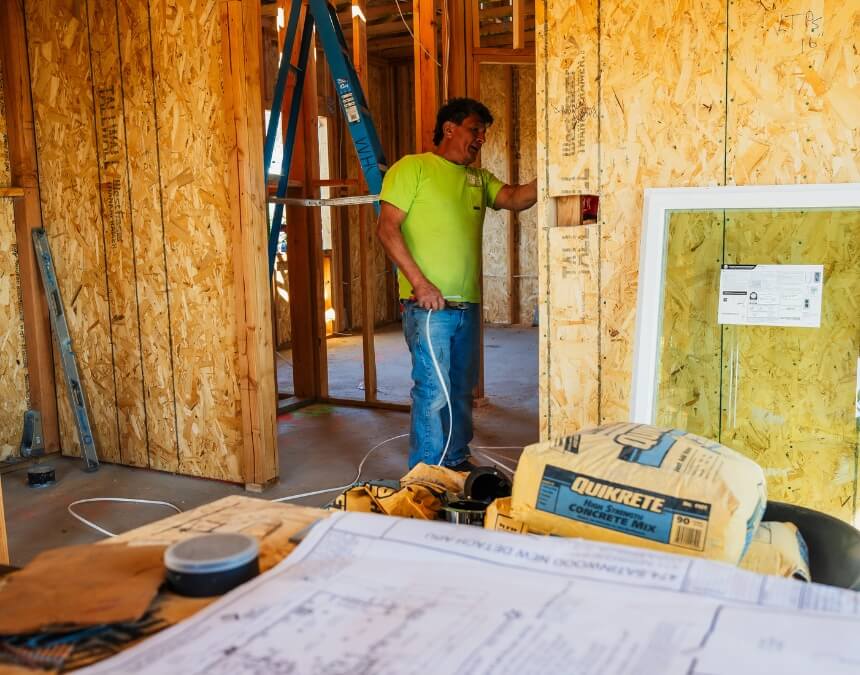 Builder examines blueprints inside wood frame structure warranty types