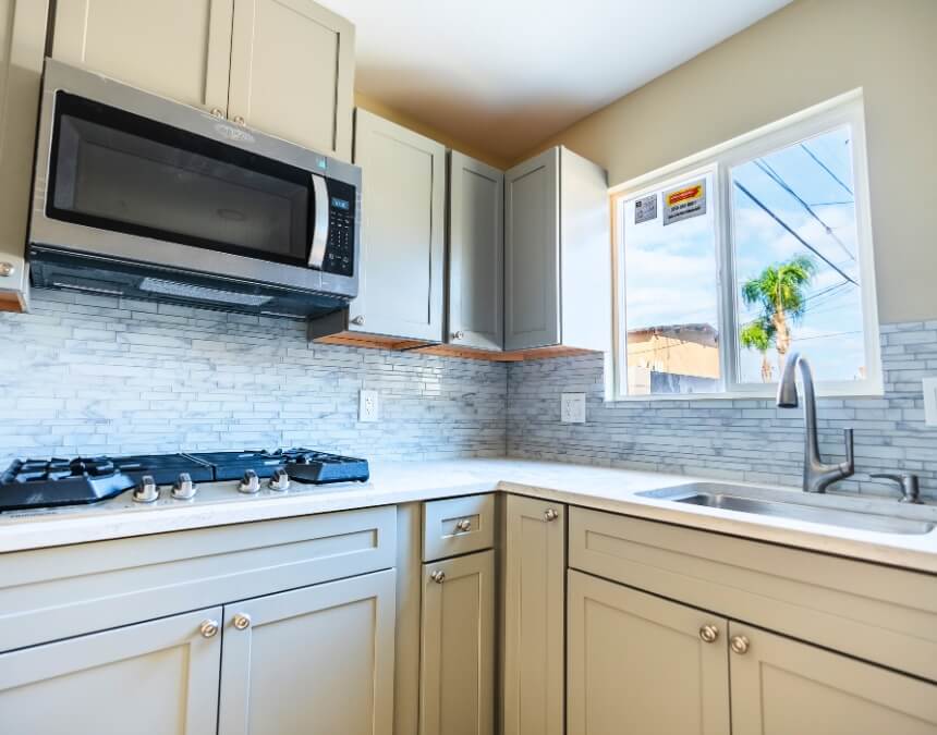 Stylish Aesthetic Options for Compact Kitchens with warm blue cabinetry and stylish living area integration