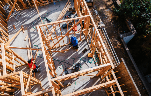 Overhead view of ADU wood framing in progress with workers on-site, illustrating the construction and final inspection phase – Build & certify