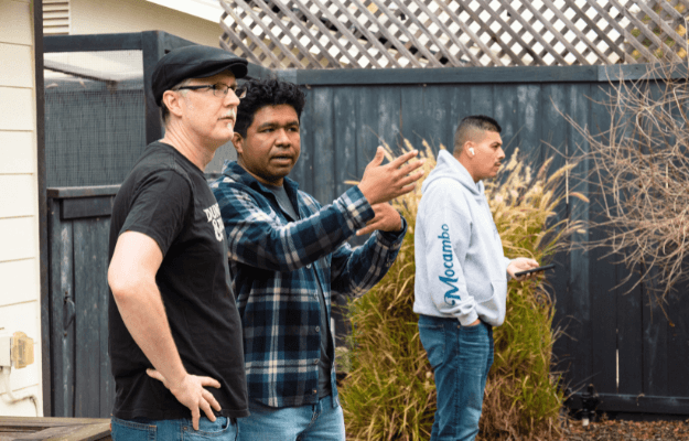Two contractors in discussion during a site walk, symbolizing the review and plan-check process for ADU approval – Navigate reviews