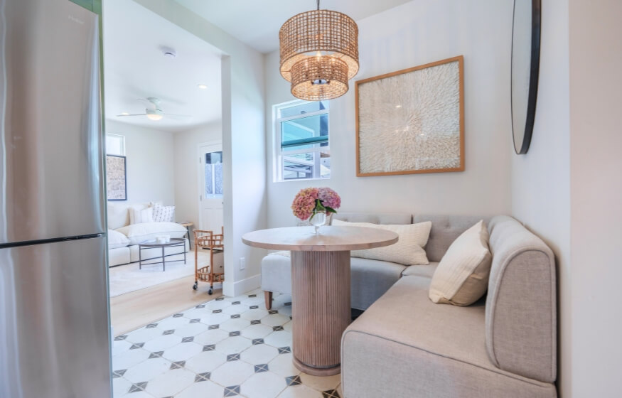 Cozy dining nook with a round pedestal table, L-shaped bench, and pendant lighting—perfect example of smart design in a 400 sq ft ADU layout.