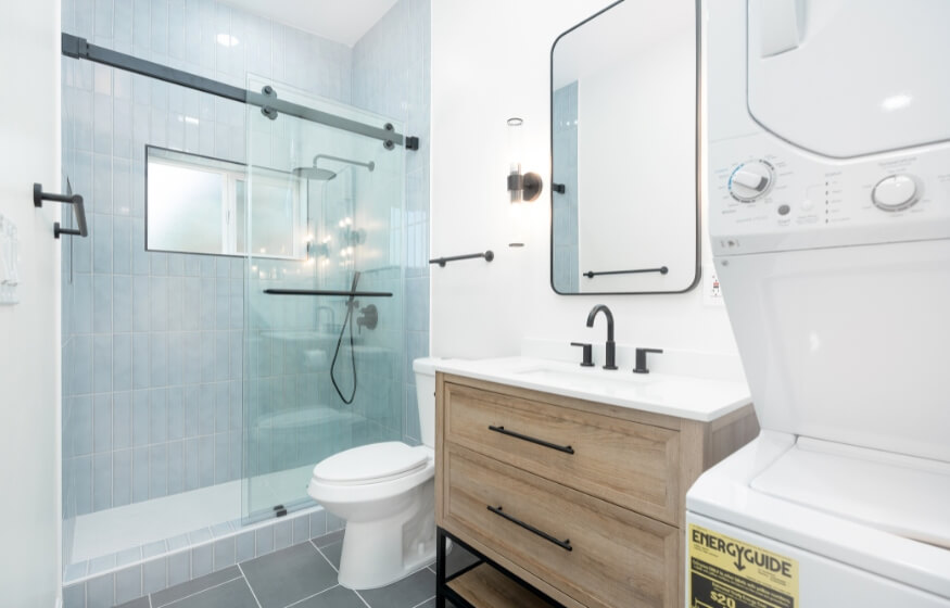 Stylish bathroom with in-unit laundry inside a 700 sq ft ADU.