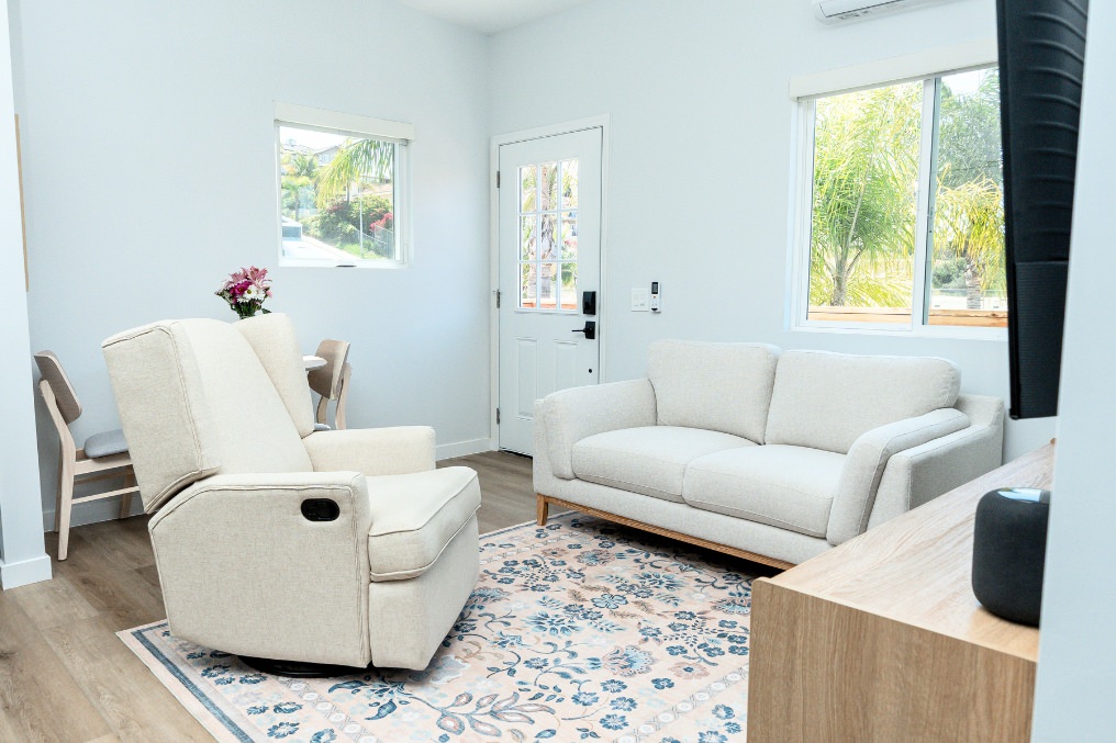 Bright, airy living room in coastal attached ADU with modern furnishings, natural lighting, and neutral decor.