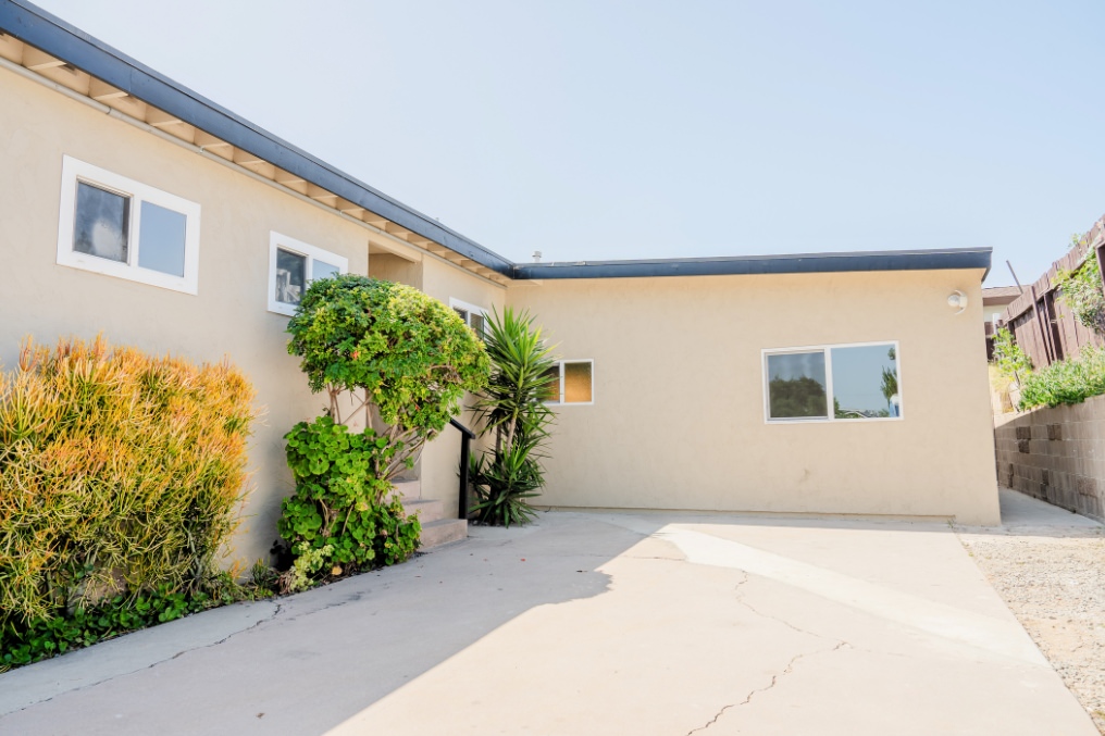 Exterior of coastal-inspired garage conversion ADU with bright landscaping