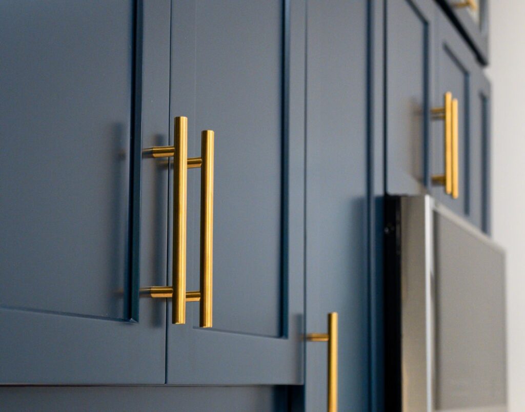 Del Mar Rental Oasis 3 close-up view of brass cabinet pulls on navy shaker cabinets.