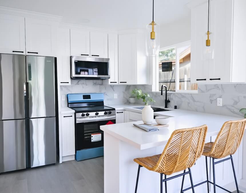 Bright and accessible ADU bedroom interior with wide doorway and view into an open kitchen.