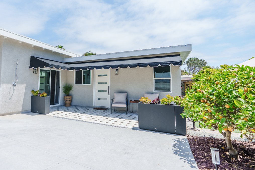 Modern boho-style detached ADU exterior with chic patio seating and lush landscaping