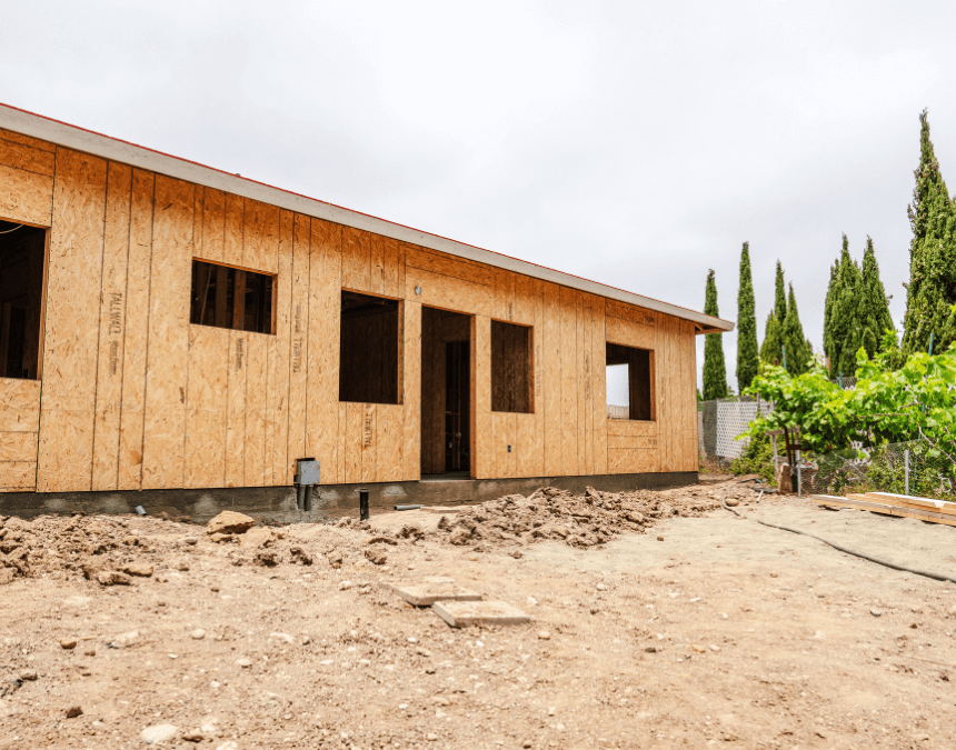 Newly framed ADU exterior with oriented strand board walls, surrounded by soil and native landscaping potential.