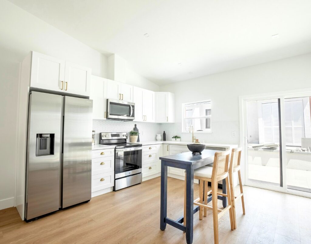 Designer-managed process showing contemporary white kitchen design with elegant seating area.