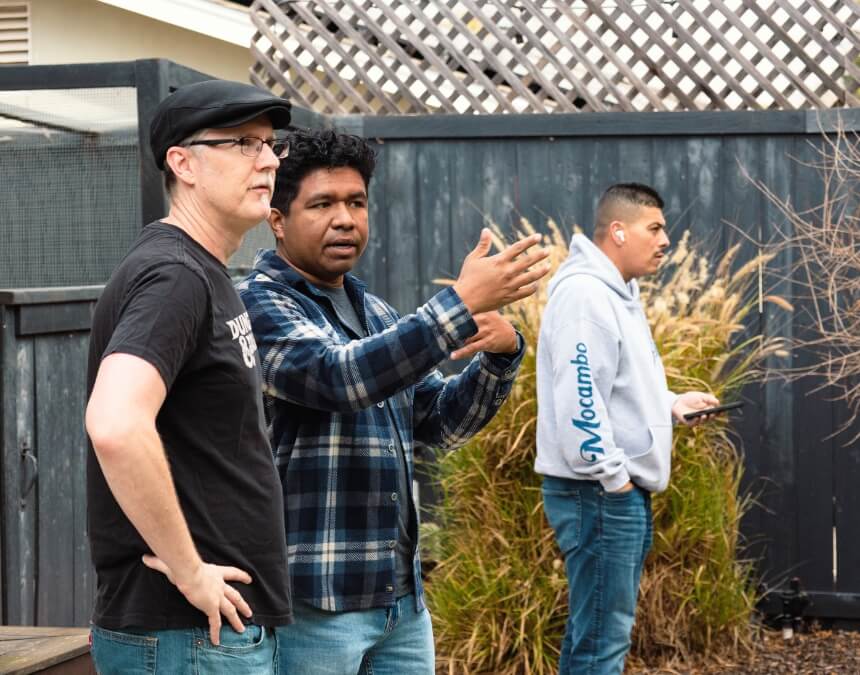 Property manager and homeowner discussing ADU logistics while another person reviews notes in the background