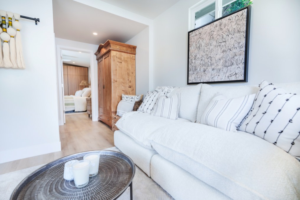 Bohemian-inspired living area with comfortable furnishings leading toward bedroom in detached ADU