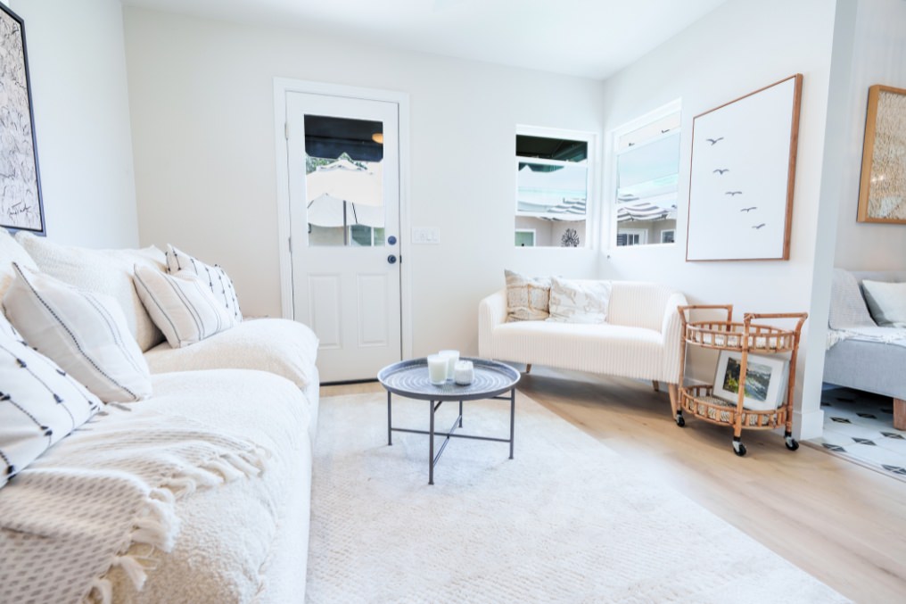 Light-filled, boho-style living room in detached ADU, featuring neutral furnishings and artistic décor