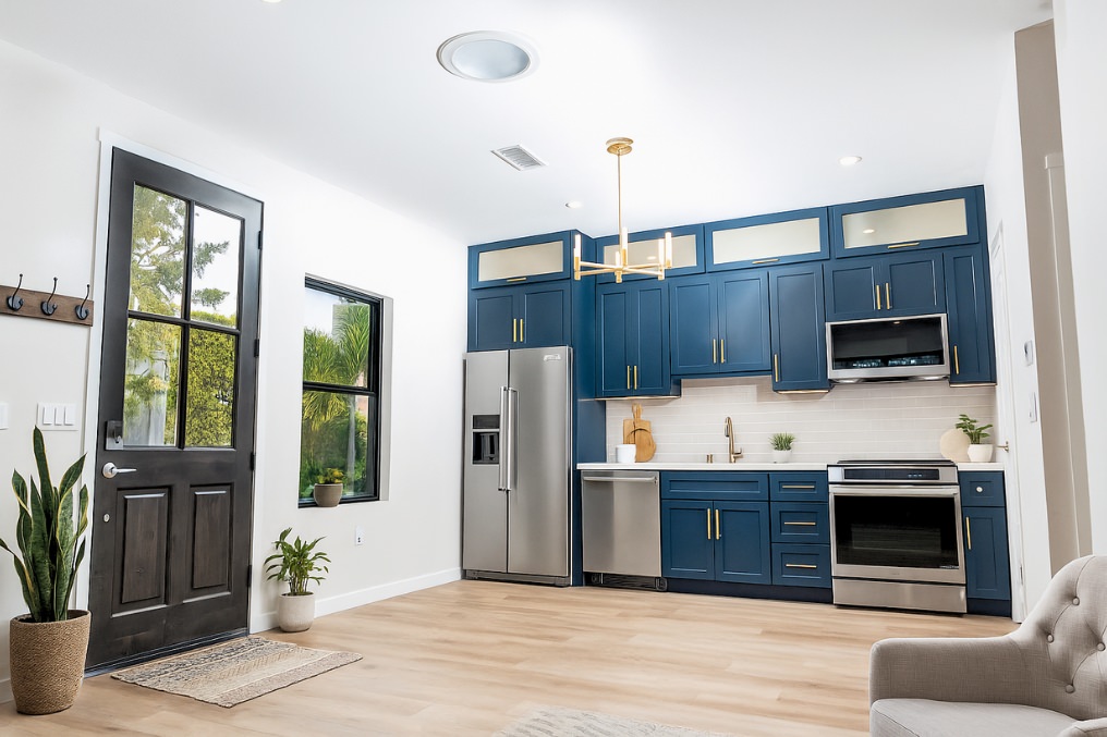 Interior of ADU featuring modern kitchen with blue cabinetry, elegant appliances, and tasteful decor.