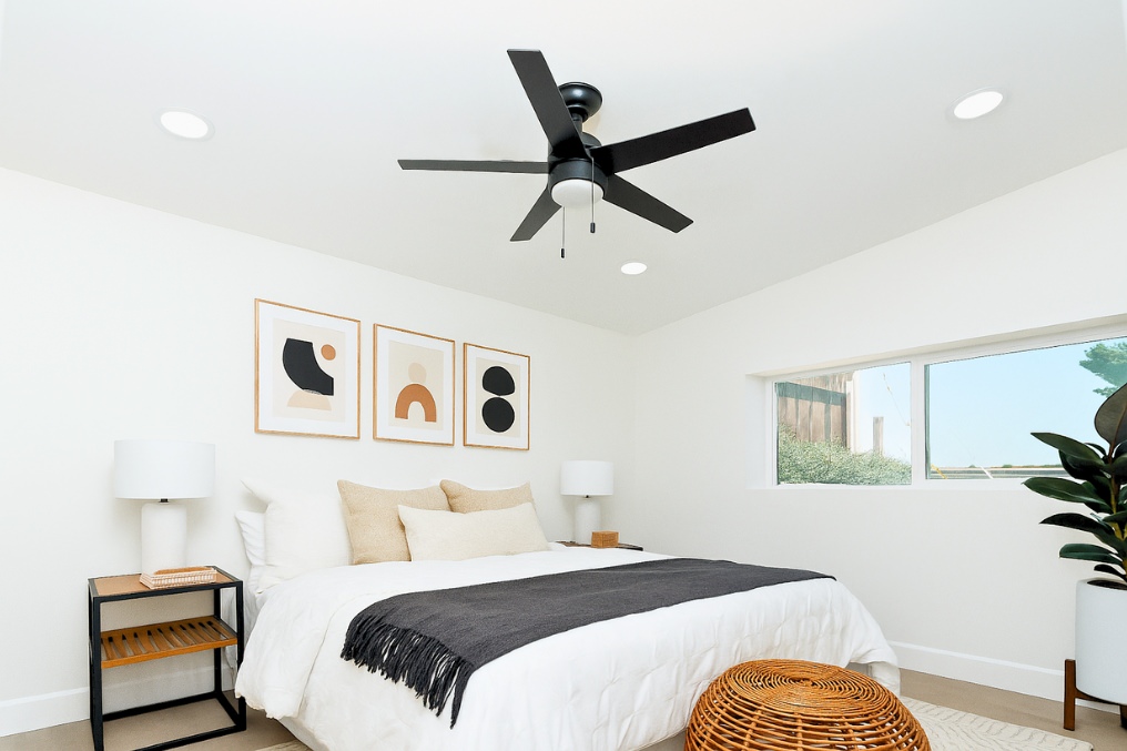 Calm bedroom featuring minimalist coastal decor and modern ceiling fan in garage conversion ADU