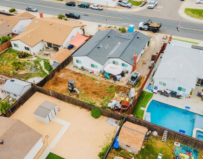 Aerial view of a San Diego backyard with active ADU construction equipment near the main home.